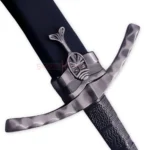 Close-up of the Ibelin sword replica hilt showing the curved crossguard, dark textured handle and decorative pommel.