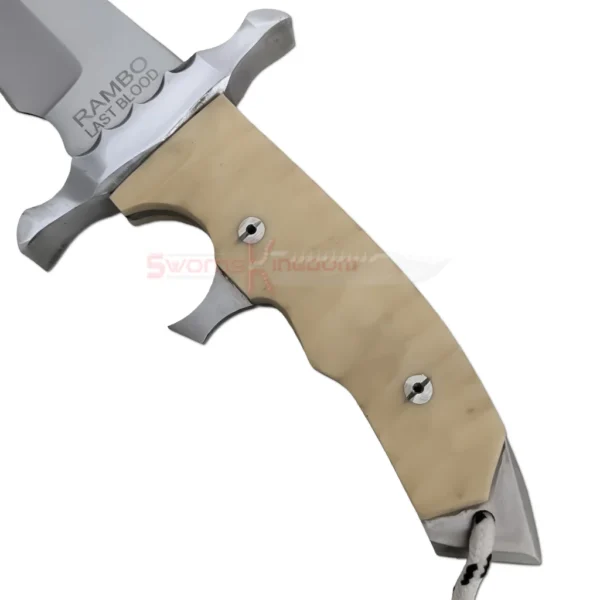 Close-up of the Rambo 5 Last Blood Heartstopper Bowie Knife Replica showing its tan handle, metal guard, and blade engraving